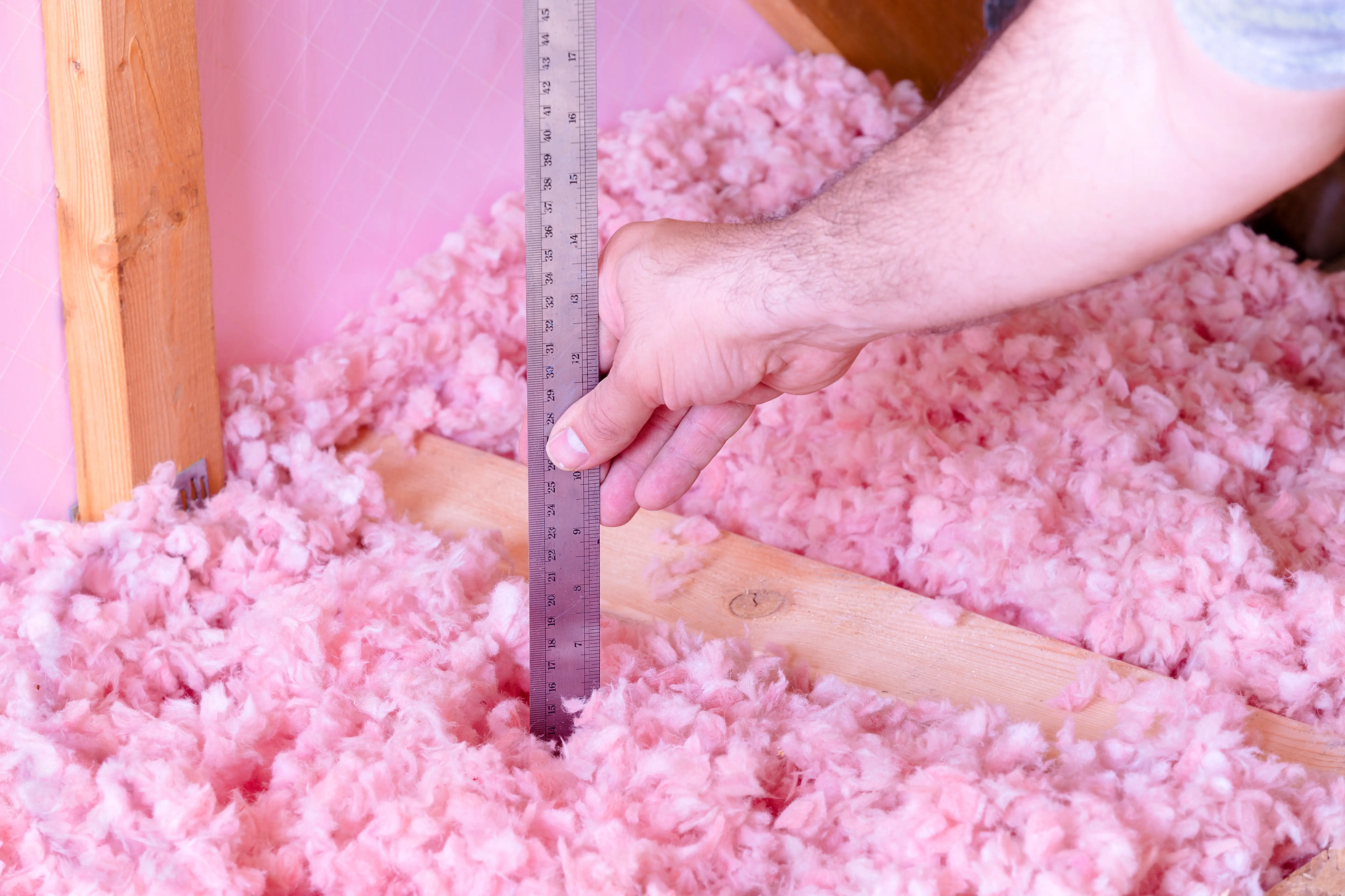 Technician installing insulation in residential crawl space