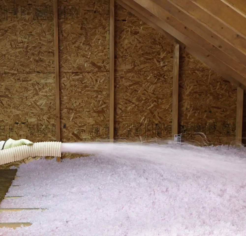 Professional installing pest control insulation in residential attic